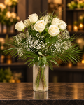 Cremeweißer Rosenstrauß mit Schleierkraut und dekorativem Grün in einer Glasvase