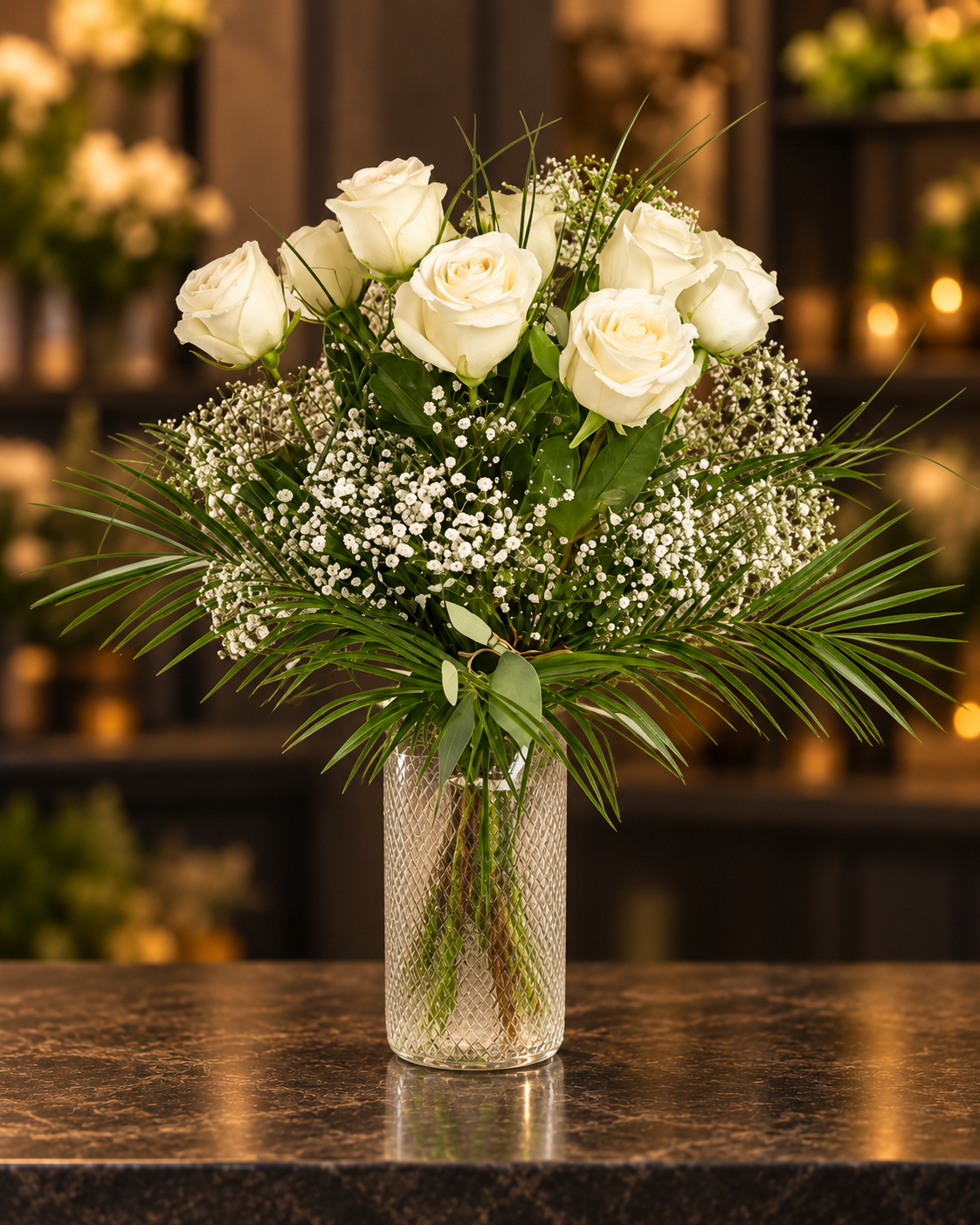 Cremeweißer Rosenstrauß mit Schleierkraut und dekorativem Grün in einer Glasvase